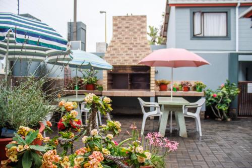 a patio with a table and chairs and umbrellas at Haus Garnison B&B in Swakopmund