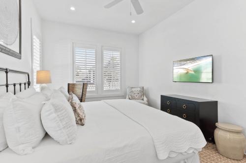 a white bedroom with a large white bed with white pillows at Grayt Digs by AvantStay Next to Beach Oceanview in Santa Rosa Beach
