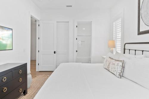 a white bedroom with a large bed and a dresser at Grayt Digs by AvantStay Next to Beach Oceanview in Santa Rosa Beach