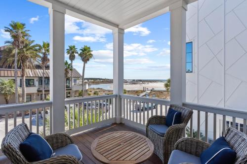 a porch with chairs and a table with a view of the beach at Grayt Digs by AvantStay Next to Beach Oceanview in Santa Rosa Beach