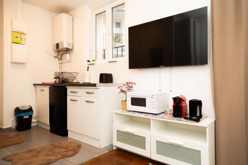 Il comprend une cuisine équipée d'un four micro-ondes et une télévision murale. dans l'établissement studio cosy Stade de France 11 pour 2 personnes, à Saint-Denis