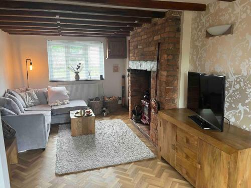 a living room with a couch and a television at Bridle Cottage in Pentrich