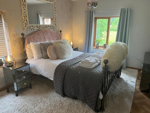 a bedroom with a bed with a large mirror at Bridle Cottage in Pentrich
