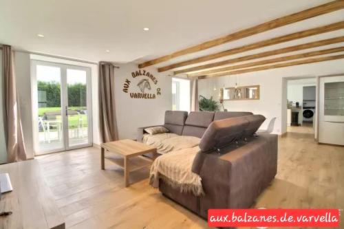 un salon avec un canapé et une table dans l'établissement Charming cottage with boulodrome near Brest, à Ploudaniel