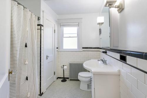 a white bathroom with a toilet and a sink at The Goat Locker in Annapolis