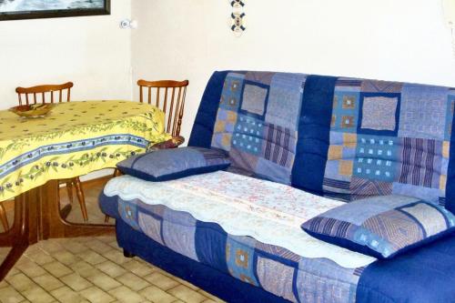 - une chambre avec un lit et un canapé avec une couverture dans l'établissement Maison charmante à Hourtin avec jardin clôturé, à Hourtin