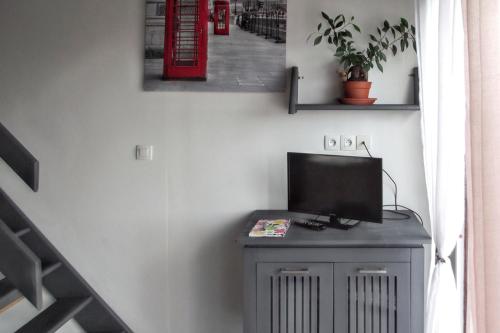 une télévision assise au-dessus d'un meuble dans une pièce dans l'établissement Studio confortable à Pédernec - 27m² - Terrasse ensoleillée, à Pédernec