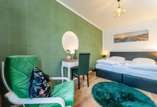 a hotel room with a bed and a chair and a mirror at Pension Michelangelo in Eisenach