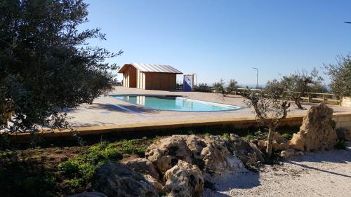 a swimming pool in a yard with a building at Agriturismo Duca di San Martino in Partanna