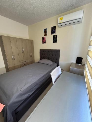 a small bedroom with a bed and a air conditioner at Apartamento cerca a aeropuerto in Valledupar