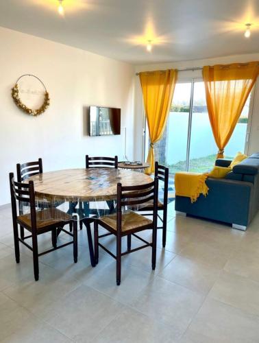 une salle à manger avec une table, des chaises et un canapé dans l'établissement La Glacière, à Étaules