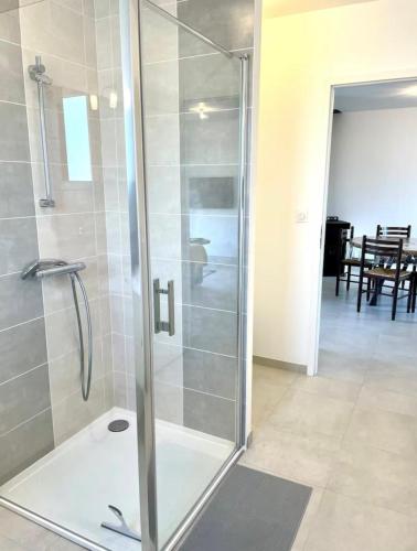 une douche avec une porte vitrée dans une salle de bain dans l'établissement La Glacière, à Étaules