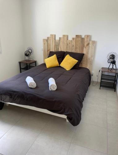 - une chambre avec un grand lit et 2 oreillers jaunes dans l'établissement La Glacière, à Étaules