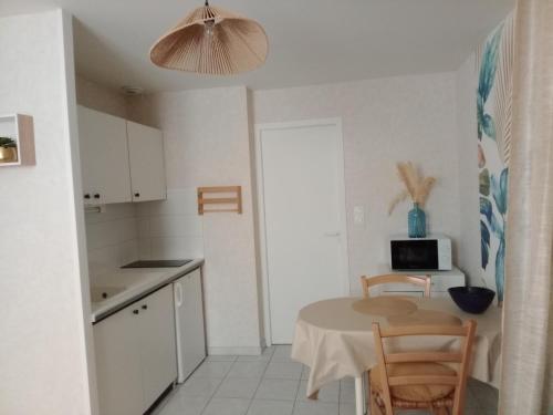 une petite cuisine avec une table et un micro-ondes dans l'établissement Studio remblai, port, commerces, à Les Sables-dʼOlonne