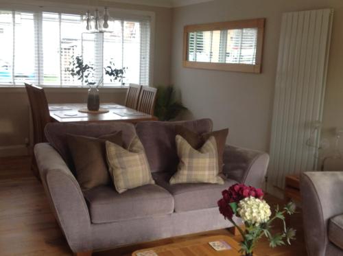 a living room with a couch and a table at Lovely Riverside Holiday Home in Callander