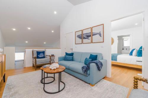 a living room with a blue couch and a bed at Varanda Azul - Lookout Loft (City Centre) in Ponta Delgada