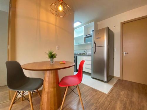 a kitchen with a table and two chairs and a refrigerator at Centro, Ar Cond, WI-FI and Lava e Seca in Santa Maria