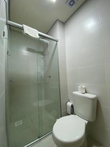 a bathroom with a toilet and a glass shower at Centro, Ar Cond, WI-FI and Lava e Seca in Santa Maria
