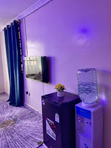 a purple room with a vase on top of a table at Bella Homes Thika Town Studio in Thika