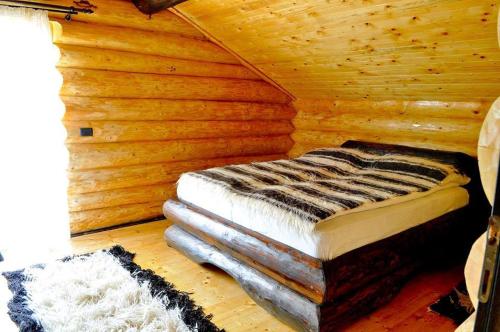a log cabin with a bed in a room at Hanul Prislop in Statiunea Borsa