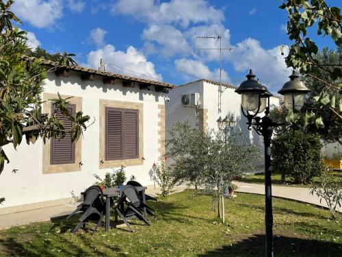 a group of tables in a yard next to a building at Le Case Al Quadrato Residence in Siracusa