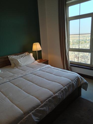 King Abdullah Economic Cityにあるجوهرة أبراج المارينا Jawhara Al Marinaの大きなベッドと大きな窓のある寝室