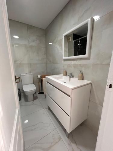a white bathroom with a sink and a toilet at Ocean Dream Apartment- Air Condition in Funchal