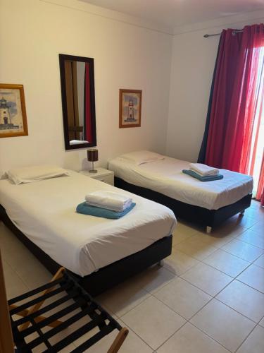 two twin beds in a room with a mirror at casa de praia Nunes Village in Porto Santo