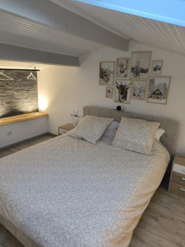 une chambre avec un grand lit avec des oreillers dessus dans l'établissement Superbe maison au calme, à Saint-Martin-Vésubie