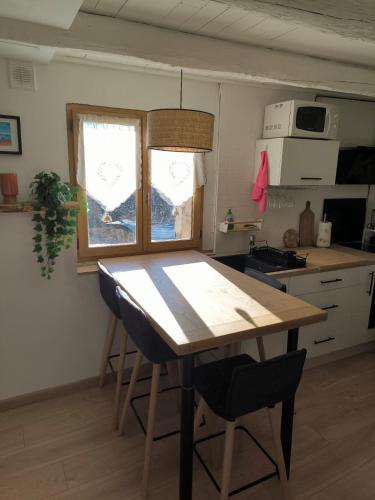 une cuisine avec une table en bois et deux chaises dans l'établissement Superbe maison au calme, à Saint-Martin-Vésubie