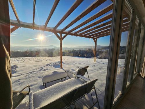 a snow covered porch with a view of the mountains at Widokowe Stodoły Bieszczady - domy z panoramą połonin in Lesko