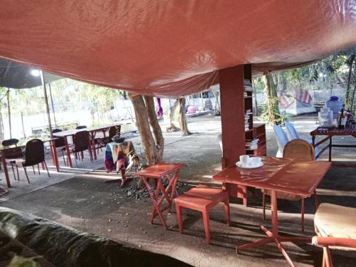 a table and chairs sitting under a tent at SECLUDED GLAMPING YOGA SAMADHI fan 2 kubos 8 pax in Rimus