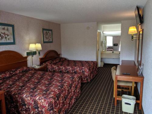 una camera d'albergo con due letti e una scrivania di Economy Inn Express a Rock Hill