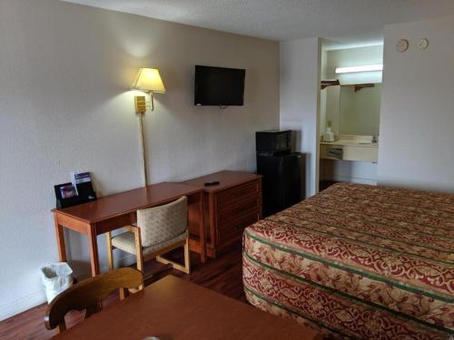 a hotel room with a bedroom with a desk and a bed at Economy Inn Express in Rock Hill