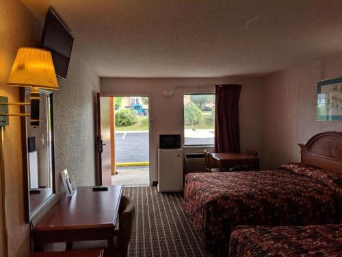 a hotel room with two beds and a table at Economy Inn Express in Rock Hill