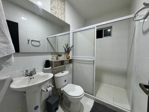 a white bathroom with a toilet and a sink at Hermoso Apartamento en la mejor zona de Montería in Montería