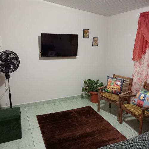 a living room with a flat screen tv on a wall at Palmenhaus in Pomerode