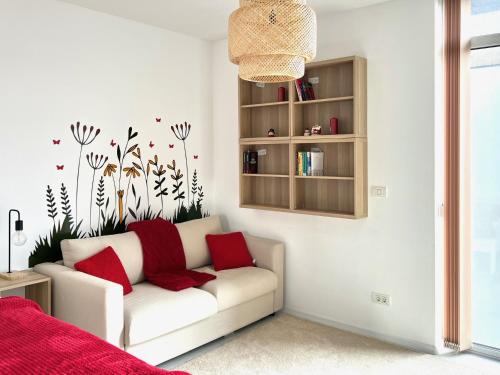 - un salon avec un canapé blanc et des oreillers rouges dans l'établissement One Apartments NordOne Iulius Town, à Timişoara