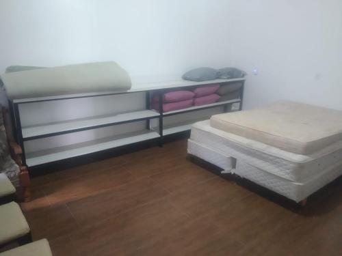 ペーニャにあるCasa na Praia Pertinho do marの棚にマットレス2枚が備わる客室です。