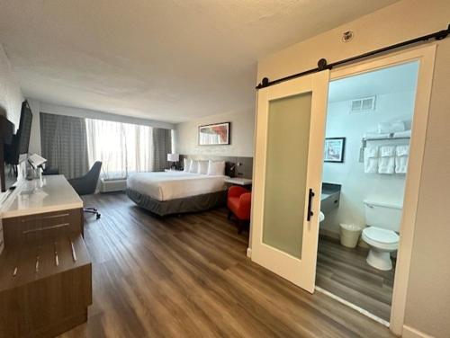 a room with a bedroom with a bed and a bathroom at Wyndham Garden Norfolk Downtown in Norfolk