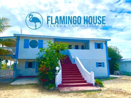 a building with a staircase leading to a house at Flamingo House - Turks & Caicos in Turtle Cove