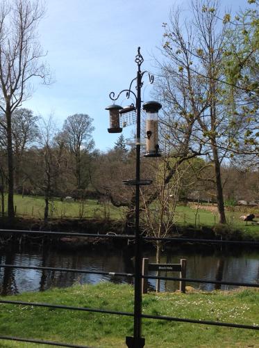 a street light next to a river with two towers at Lovely Riverside Holiday Home in Callander