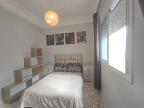 a small bedroom with a bed and a window at Mounia Moon in Casablanca