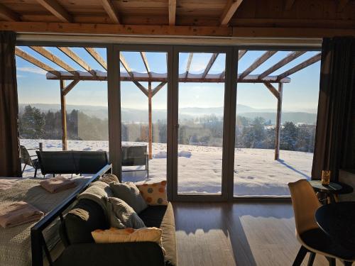 ein Wohnzimmer mit einem großen Glasfenster mit Aussicht in der Unterkunft Widokowe Stodoły Bieszczady - domy z panoramą połonin in Lesko