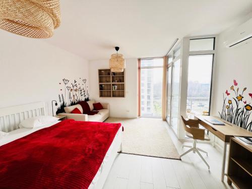 a white room with a red bed and a desk at One Apartments NordOne Iulius Town in Timişoara