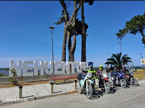 a group of people on motorcycles parked next to a sign at Costa Monkul - Carahue y Puerto Saavedra in Nahuentúe