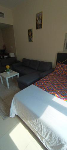 a living room with a couch and a bed at Daily Basis Furnished rooms Deira in Dubai