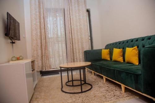 un soggiorno con un divano verde e un tavolo di La Perle de Ville a Kigali