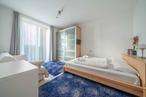 a bedroom with a large bed and a blue rug at Italian Lake Getaway in Maccagno Superiore