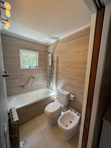 a bathroom with a toilet and a tub and a sink at Rincón del Angel in San Carlos de Bariloche
